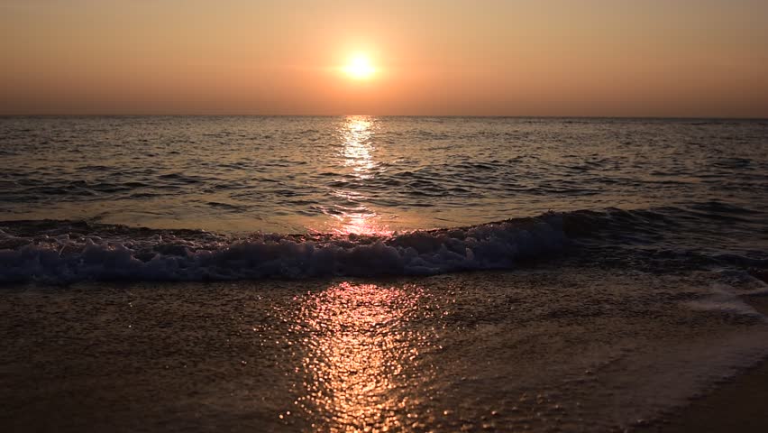 abstract washed-out sea with wave and foam, shoreline in the sunset light, glare and bokeh, sunset on the beach, Footsteps in the sand on the beach