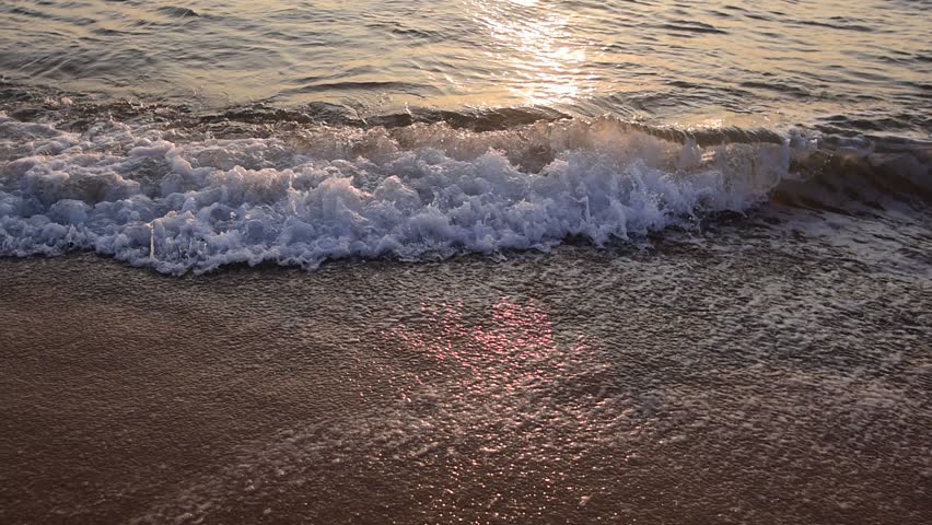 abstract washed-out sea with wave and foam, shoreline in the sunset light, glare and bokeh, sunset on the beach, Footsteps in the sand on the beach