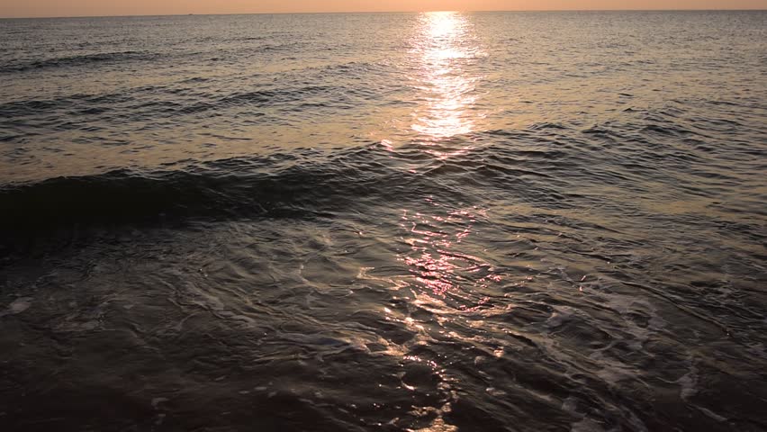 abstract washed-out sea with wave and foam, shoreline in the sunset light, glare and bokeh, sunset on the beach, Footsteps in the sand on the beach
