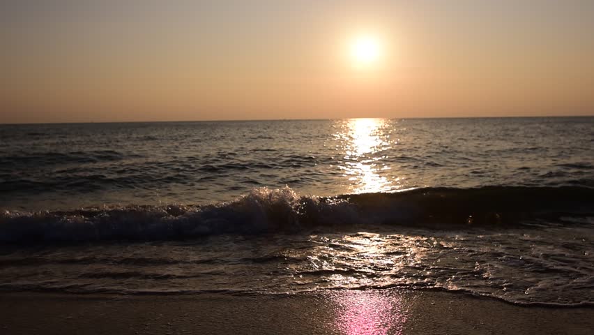 abstract washed-out sea with wave and foam, shoreline in the sunset light, glare and bokeh, sunset on the beach, Footsteps in the sand on the beach