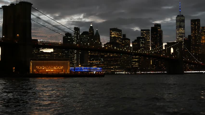 Brooklyn Bridge, New York City Manhattan downtown skyline cityscape, United States. Waterfront Pebble Beach, carousel in Dumbo, USA. Dramatic twilight dusk. Evening or night sky. World Trade Center.