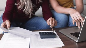 Mother teach her adult daughter to manage personal finances sit at table with laptop, planning budget, making payments via e-banking system, calculate incomes and expenses together, close up crop view - Powered by Shutterstock - Get 15% off with code: PIKWIZARD15