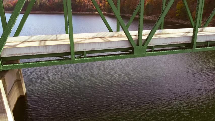 Video slowly distancing from a bridge on a lake to display the Appalachian mountains in Autumn. This is the South Holston Lake in Tennessee. 