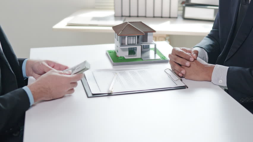 Buyer trade a cash to business people seller for house real estate purchase, loan financial and pay cash money for real estate house properties