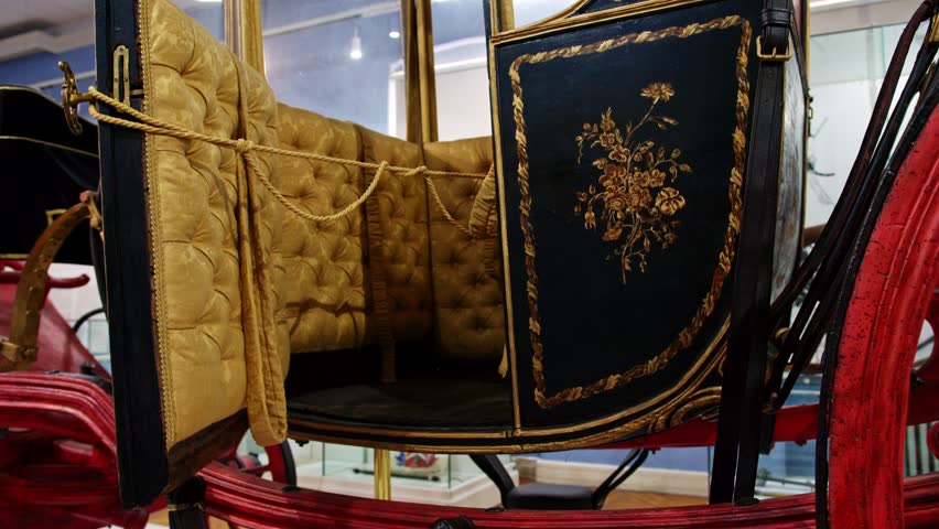 Vintage carriage with intricate embellishments displayed in a museum setting highlighting historical transportation