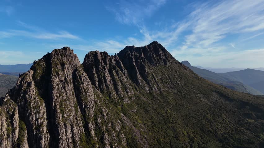Peak of Cradle Mountain in Tasmania with blue sky, Australia, aerial shot dynamic