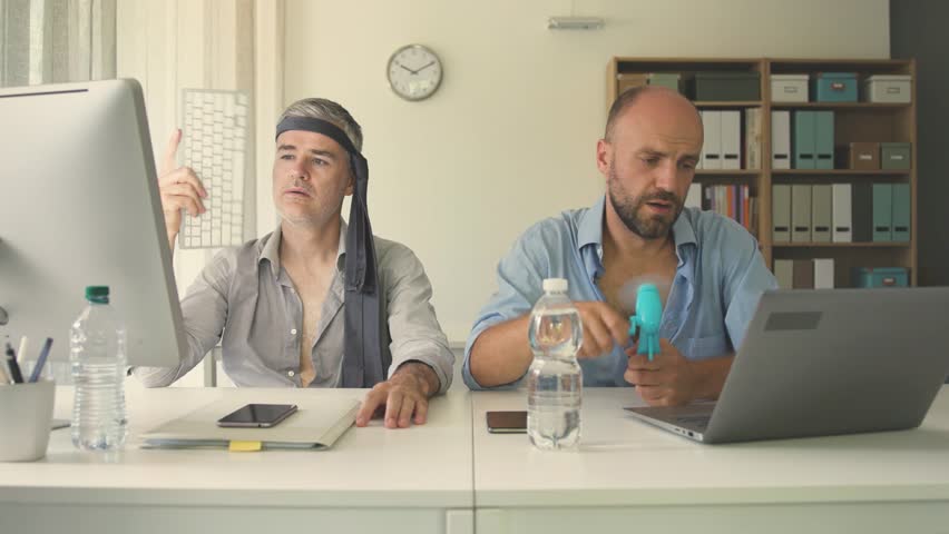 Exhausted business people suffering from the heat in the office, the AC is broken