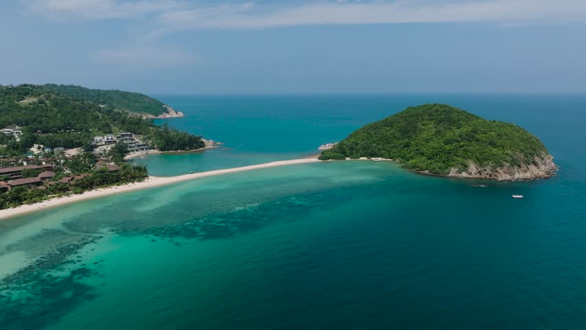 Tropical island with white sandbar surrounded by corals on turquoise sea water under clear skies. Ko Ma Beach. Ko Pha Ngan, Thailand.