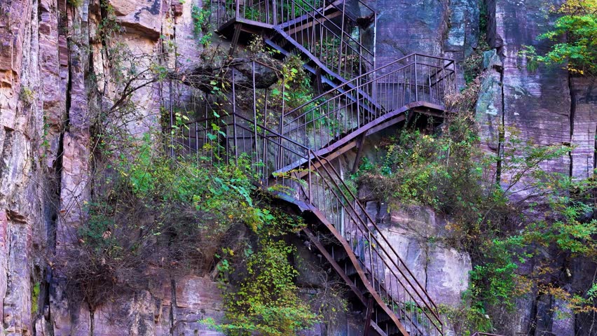 Zigzag stairway blends natural beauty and human design, carved into dramatic cliffs near Xiuyan Village, Zhejiang Province, China. Aerial view highlights its rugged charm.