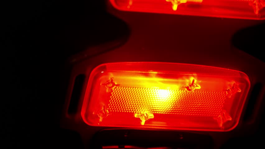 A near infrared and red light therapy device glows and moves around close to camera in a dark room