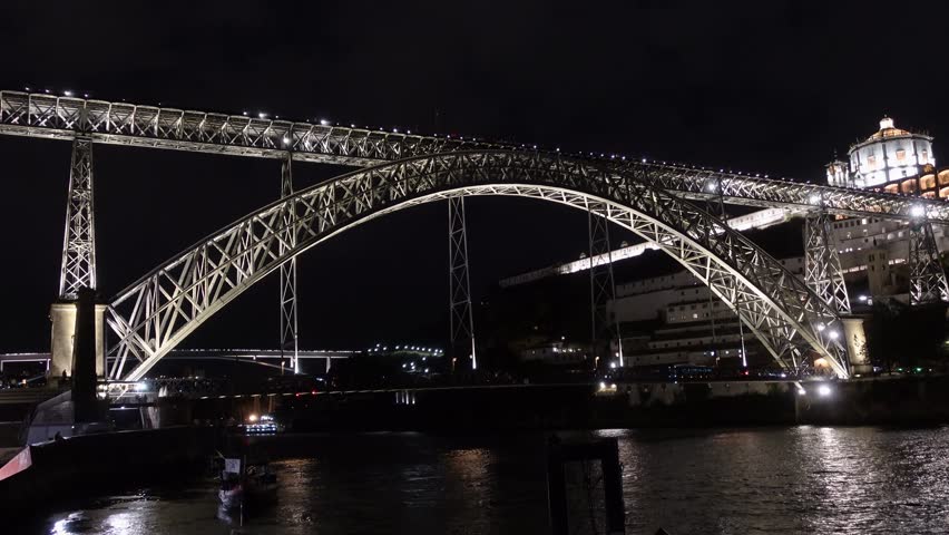 Luí I Bridge, a tall arched bridge, stands illuminated at night in Porto.