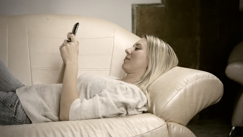 Beautiful girl on sofa , speaking by phone