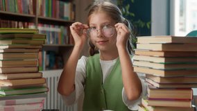 Cute adorable smiling Caucasian little girl kid schoolgirl school child pupil student learner wearing eyeglasses glasses eyewear preparing reading do homework study schoolwork in classroom education - Powered by Shutterstock - Get 15% off with code: PIKWIZARD15