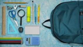 Colorful school supplies moving into school bag on blue and white blurred background. Back to school concept. Stop motion animation - Powered by Shutterstock - Get 15% off with code: PIKWIZARD15
