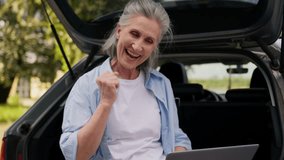 Excited laughing Caucasian senior elderly business woman mature female businesswoman freelancer looking laptop device celebrating win victory gambling clench fist gesture sit car trunk at nature park - Powered by Shutterstock - Get 15% off with code: PIKWIZARD15