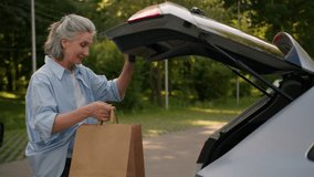 Happy elderly Caucasian shopper woman shopaholic female senior mature customer consumer automobile driver open car trunk loading puts packages in auto shopping bags products close vehicle boot outside - Powered by Shutterstock - Get 15% off with code: PIKWIZARD15