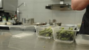 Male Chef Putting Sliced Asparagus Into Clear Plastic Containers at Restaurant - Powered by Shutterstock - Get 15% off with code: PIKWIZARD15