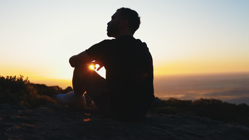 Person sitting on beach at Cape Town in golden hour.