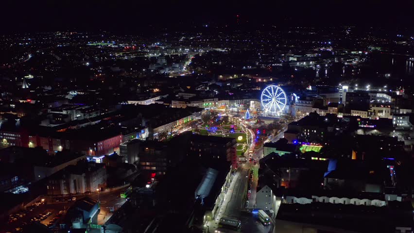 Aerial view of Galway city centre lit by Christmas lights at night, showcasing Eire Square market