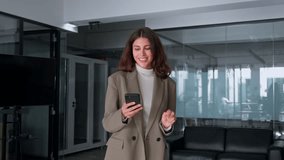 Middle aged Hispanic business manager ceo using cell phone mobile application. Smiling Latin or Indian mature woman businesswoman holding smartphone while walking in office working online on gadget - Powered by Shutterstock - Get 15% off with code: PIKWIZARD15