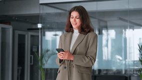 Young Indian business woman manager ceo using cell phone mobile app. Smiling Latin Hispanic mature female businesswoman holding smartphone in office for work, trading, chat with ai, working online - Powered by Shutterstock - Get 15% off with code: PIKWIZARD15