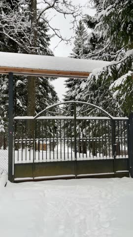 approaching metal gates in a serene winter forest. The snow-covered landscape and gate design evoke a sense of mystery, beauty, and tranquility, symbolizing privacy, security, and exclusivity