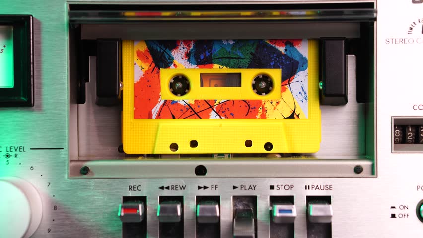 Playback of Audio Cassette Tape With Colorful Sticker Label in Vintage Deck Player From 1970's