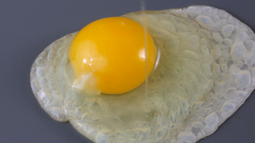 Close up HD video of egg cooking on hot griddle