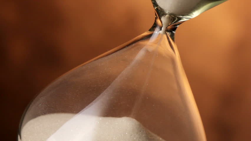 Extreme closeup of sand in hourglass, shot in HD video