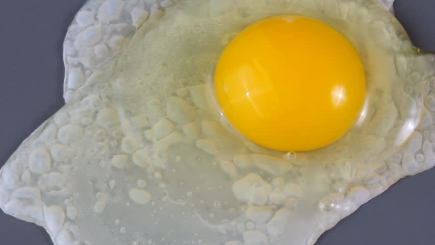 Close up HD video of an egg cooking on a griddle