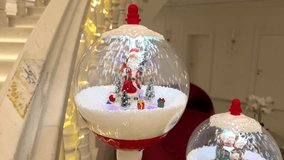 Closeup of snow globe lamp post in red with Santa scene. Cascading Snow. Christmas decoration in a hotel lobby. Christmas spirit. Faux snow. Holiday season. - Powered by Shutterstock - Get 15% off with code: PIKWIZARD15