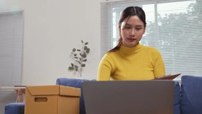 Young Asian entrepreneur checking online orders, tracking inventory with clipboard while working from home office laptop - Powered by Shutterstock - Get 15% off with code: PIKWIZARD15