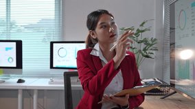 Young businesswoman analyzing financial data on an interactive display, taking notes on a clipboard - Powered by Shutterstock - Get 15% off with code: PIKWIZARD15