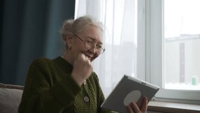 Happy senior woman triumphantly raising her fist after achieving victory in an online game using her tablet - Powered by Shutterstock - Get 15% off with code: PIKWIZARD15