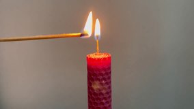 Single pink candle burning. Shot. Isolated on white background candle burning. Red wax candle with yellow burns from match. - Powered by Shutterstock - Get 15% off with code: PIKWIZARD15