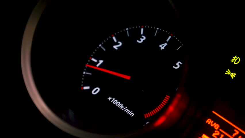Close up of car speed meter. Footage. Interior of a modern car, dashboard with an engine speed dial and moving red arrow.