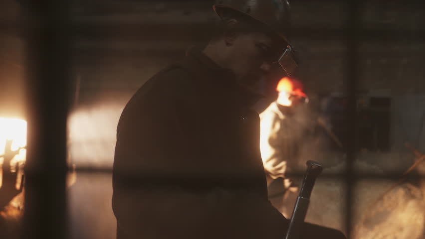 Industrial Workers Operating and Thriving Amidst a Smoky and Challenging Atmosphere. Stock Clip