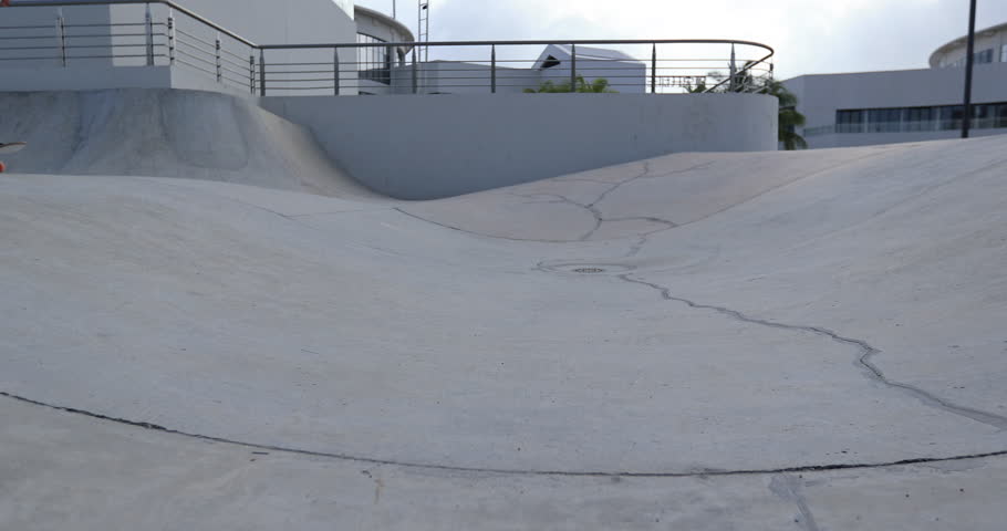 Skateboarder skateboarding at skatepark in city, slow motion