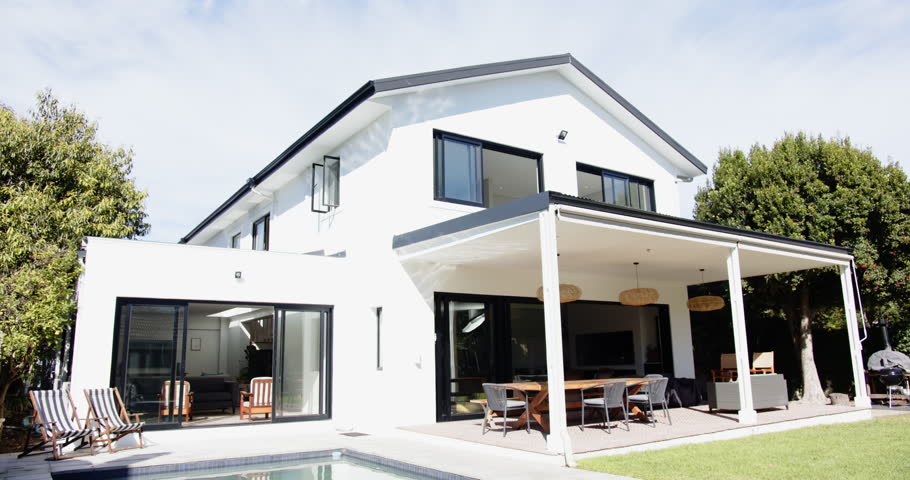 Modern house with swimming pool and outdoor dining area in backyard. Architecture, luxury, home, exterior, lifestyle, garden