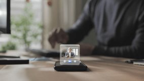 Person at the desk using computer receiving business video call on smart phone screen,co-workers having remote work online meeting briefing via virtual display app - Powered by Shutterstock - Get 15% off with code: PIKWIZARD15