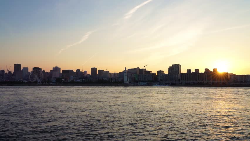 Old Port of Montreal and downtown skyline at night. Colorful buildings lights reflected in water. Montreal city, Quebec, Canada.