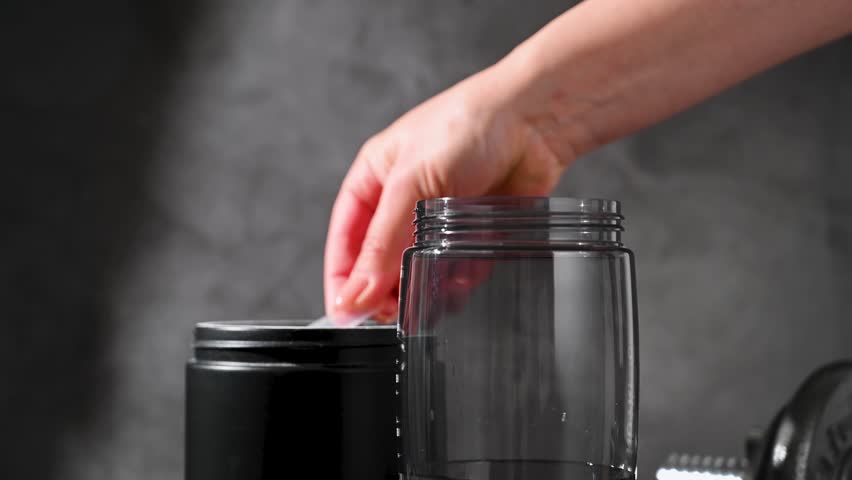 Amino acid food supplement, creatine powder in a measuring scoop and plastic jar