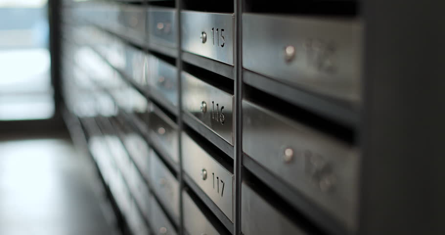 Close up woman inserting letter in mailbox. Mail delivery. Mail shipping concept.