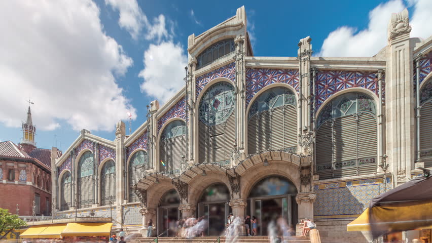 Valencia Central Market timelapse hyperlapse. Historic public market with stunning architecture, stained glass, dome and tile details. Located in Market Square near Santos Juanes Church. Spain