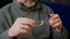 Examining old glasses with scratched lenses. Analyzing worn-out spectacles with visible wear on lenses. Inspecting vintage eyeglasses for signs of damage - Powered by Shutterstock - Get 15% off with code: PIKWIZARD15