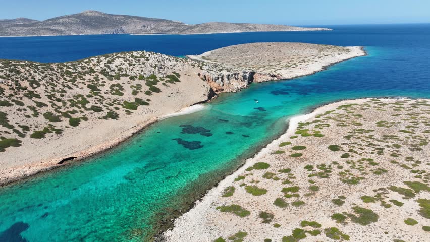 Aerial drone cinematic video of paradise emerald bay of Koutsomitis islet resembling a blue lagoon a favourite place for yachts and sailboats, Astypalaia island, Dodecanese, Greece