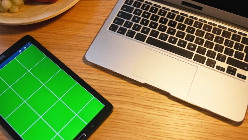 A modern workspace featuring a laptop and a tablet elegantly positioned on a wooden table