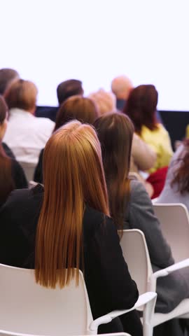 Conference with female audience, the symposium meeting, participants attendees in room hall listen to lecturer, group of women on a congress together listen to speaker on stage at master-class event