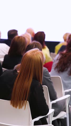 Conference with female audience, the symposium meeting, participants attendees in room hall listen to lecturer, group of women on a congress together listen to speaker on stage at master-class event