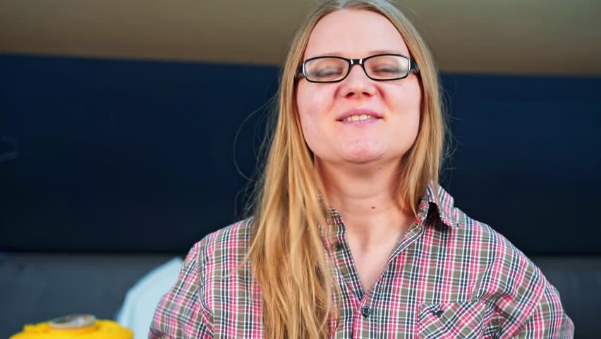 Portrait of positive woman in glasses with long hair, respondent at interview, embarrassed by awkward delicate questions, nervously straightens hair, flirts feignedly, laughs it off Blogger broadcast